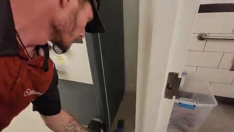 mover working a large gray safe in a doorway, face visible